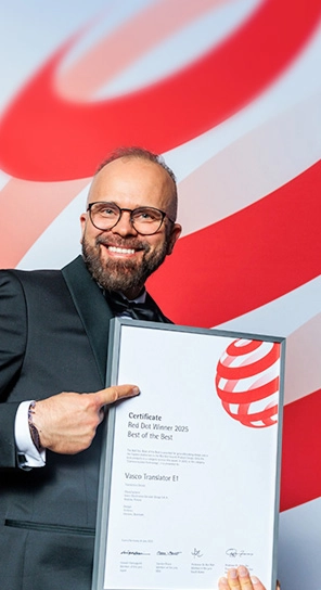 Generálny riaditeľ spoločnosti Vasco Electronics drží ocenenie Red Dot a predstavuje ocenené zariadenia.