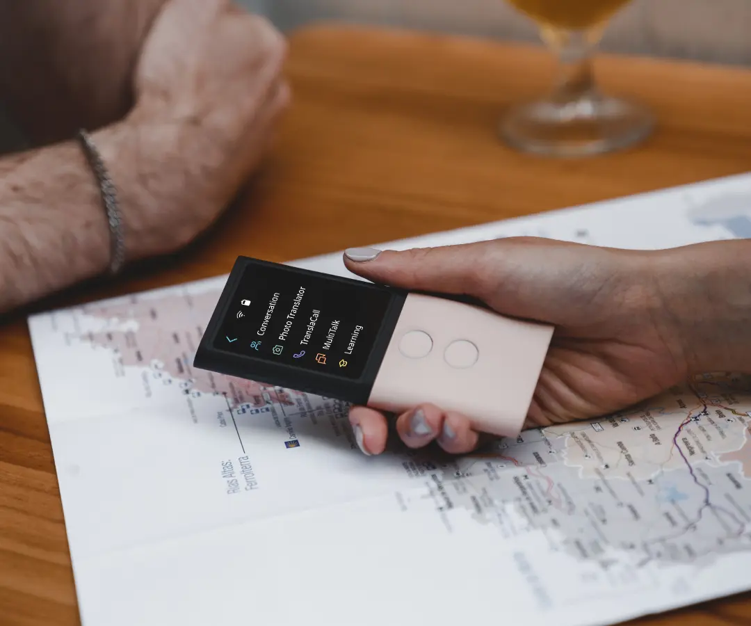 Detailný záber ruky, ktorá drží prekladač nad stolom s mapou